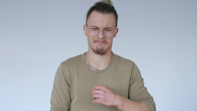 The man is disgusted, nauseous. Dislike concept. A person suffering from heartburn.