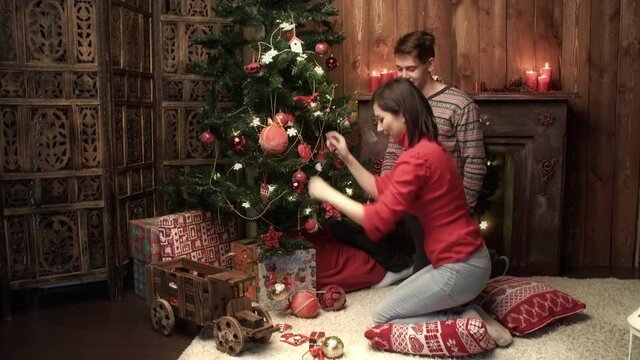 Happy couple decorating xmas tree at home. Relationship, family, christmas, new year, holiday concet.