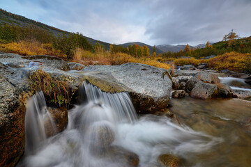Fototapeta na wymiar Mountain stream on a cloudy autumn day
