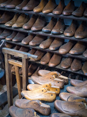 Shoemakers model for shoes in his workshop