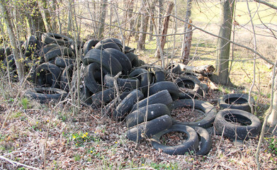 Fototapeta na wymiar heap of old car tyres in the nature, ecological problem