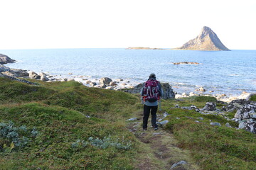 man walking with island and sea in the background