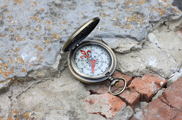 Iron compass on brick wall as symbol of tourism with compass, travel with compass and outdoor activities with compass