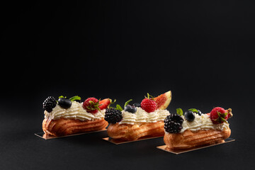 Homemade eclairs with cream and fresh berries.