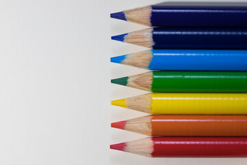 Coloured pencil crayons on a white background. Rainbow colours
