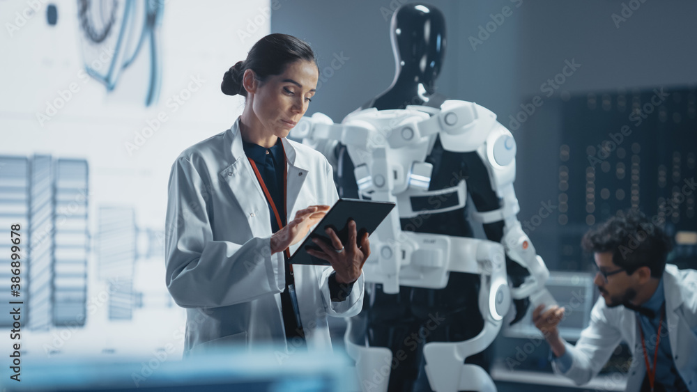Poster in development laboratory: portrait of a beautiful chief female engineer using digital tablet comput