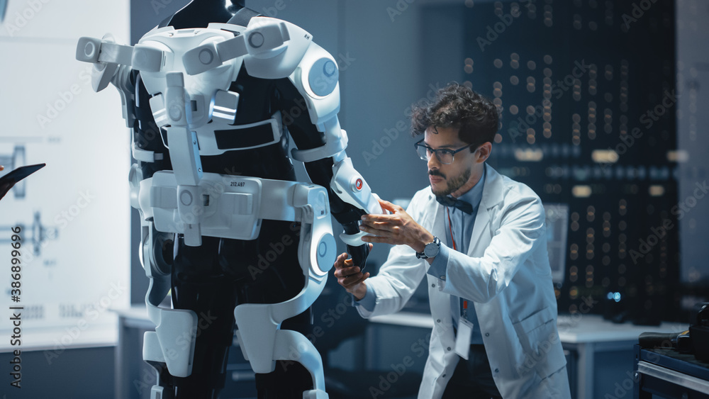 Poster in robotics development laboratory: top male scientist works on a bionics exoskeleton prototype. tea