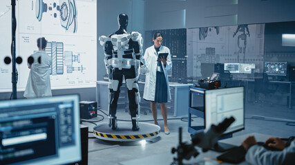 In Robotics Development Laboratory: Female Scientist Uses Digital Tablet Computer, Work on a...