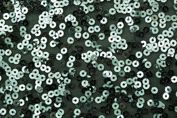 Close up photo of circle green sequins on fabric