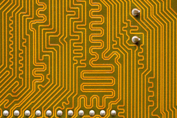 Close-up of a yellow circuit board. The reverse side of the motherboard of a personal computer....