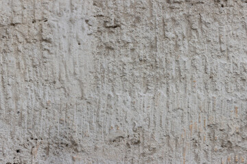 Rough uneven surface of the plastered wall.