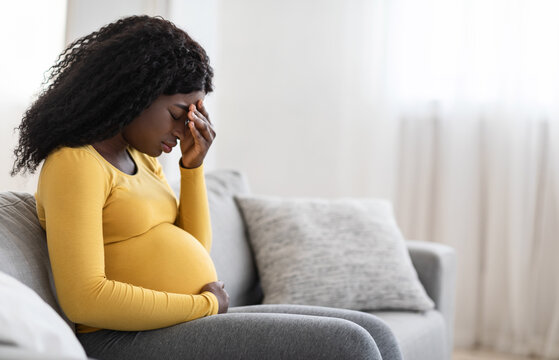 Young pregnant black woman suffering from headache or migraine