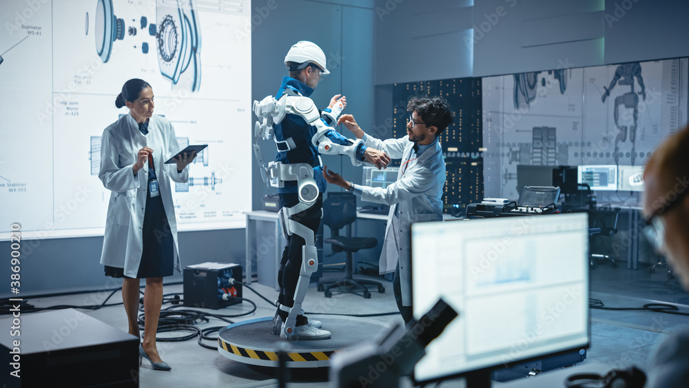 Leinwandbilder In Robotics Development Laboratory: Engineers and Scientists Work on a Bionics Exoskeleton Prototype with Person Testing it. Designing Wearable Exosuit to Help Disabled People, Warehouse Workers