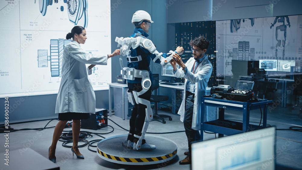 Fototapete In Robotics Development Laboratory: Engineers and Scientists Work on a Bionics Exoskeleton Prototype with Person Testing it. Designing Wearable Exosuit to Help Disabled People, Warehouse Workers