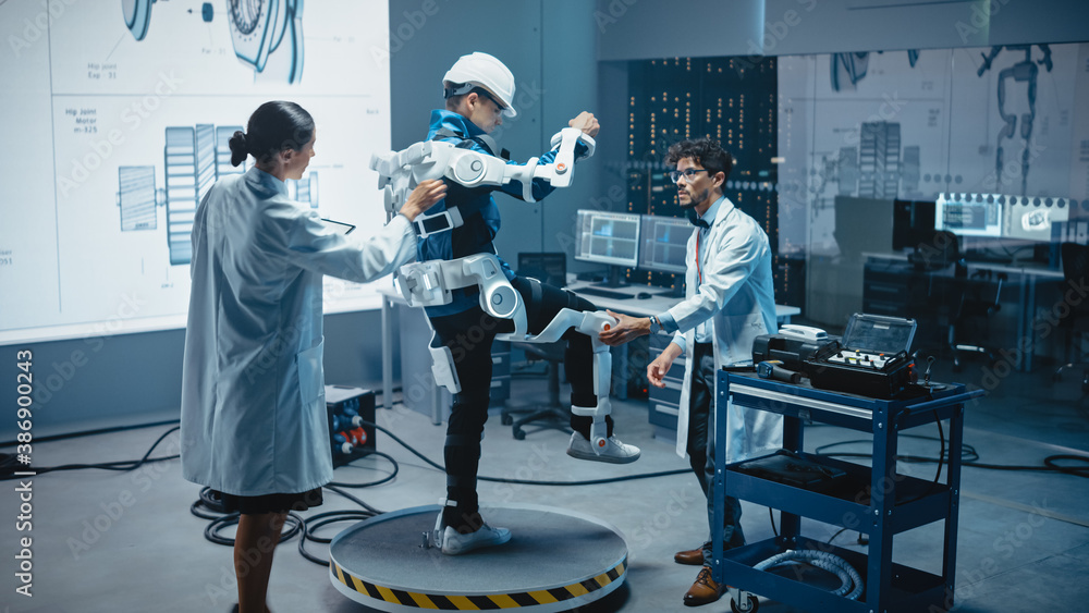 Leinwandbilder In Robotics Development Laboratory: Engineers and Scientists Work on a Bionics Exoskeleton Prototype with Person Testing it. Designing Wearable Exosuit to Help Disabled People, Warehouse Workers