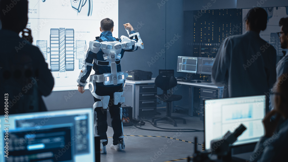 Leinwandbilder In Development Laboratory: Engineers and Scientists Look at Robotics Exoskeleton Prototype Presentation with Person Testing it, Moving and Raising His Hand. Designing Wearable Exosuit to Help People