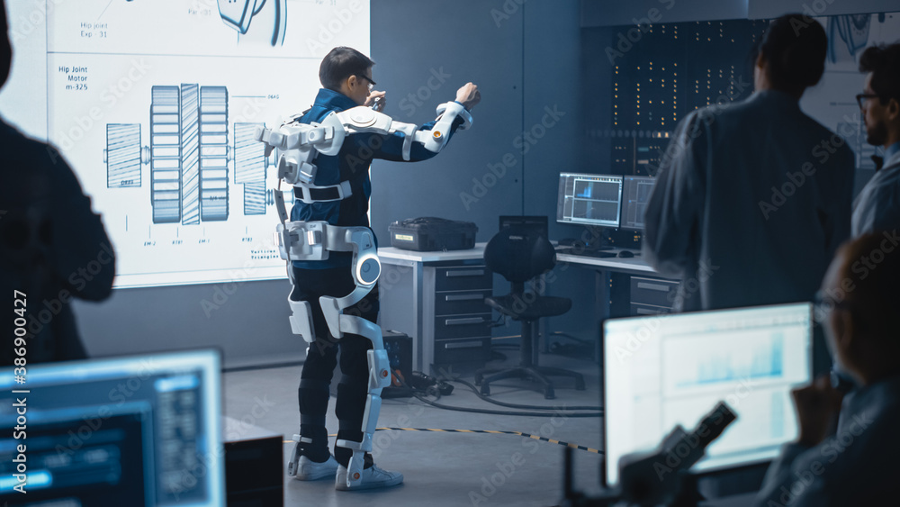 Leinwandbilder In Development Laboratory: Engineers and Scientists Look at Robotics Exoskeleton Prototype Presentation with Person Testing it, Moving and Performing. Designing Wearable Exosuit to Help People