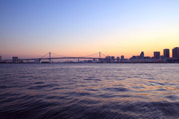 東京湾とビル群の夕暮れとレインボーブリッジ