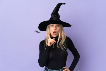 Young woman with witch costume over isolated background thinking an idea pointing the finger up