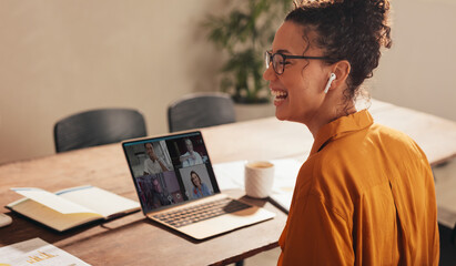 Business woman laughing during a video call with team