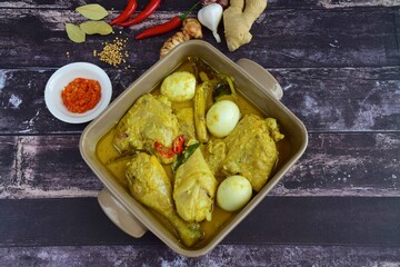 Opor ayam, chicken cooked in coconut milk added with boiled eggs. Originated from Central Java, Indonesia, served with sambal. Popular dish for lebaran or Eid al-Fitr 