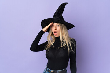 Young woman with witch costume over isolated background doing surprise gesture while looking to the side