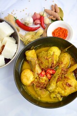 Opor ayam, chicken cooked in coconut milk from Indonesia, from Central Java, added with boiled eggs, served with lontong and sambal. Popular dish for lebaran or Eid al-Fitr