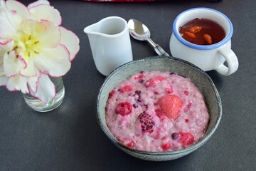 Oatmeal porridge with blueberry, raspberries, blackberry, strawberry and red currants. Healthy diet breakfast. Black background