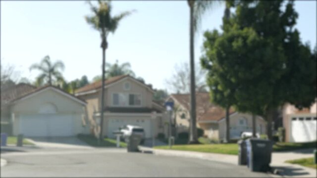 Suburb real estate, property in residential district, San Diego county, California USA. Defocused typical suburban neighborhood. Detached single-family houses, expensive realty. Row of classic homes.
