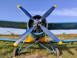 Piston engine of an old biplane plane with a blue propeller close up