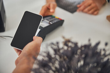 Customer paying for a purchase with a help of phone