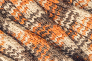 Texture of a warm knitted woolen fabric. Autumn background in brown tones