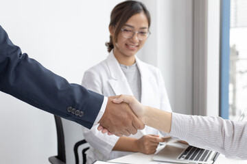 Partners shake hands to congratulate them on joining the business.