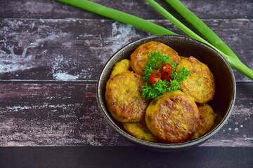 Perkedel, Indonesian fried potato minced beef patties garnish with parsley and chili in a bowl 
