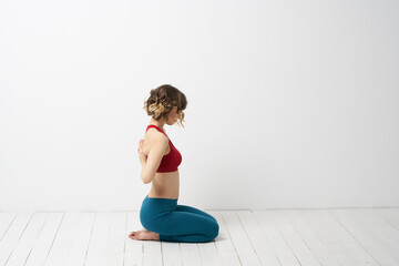 the girl is engaged in yoga on a light background Red T-shirt gesticulating with his hands