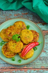 Perkedel, Indonesian fried potato minced beef patties garnish with parsley and chili in a bowl 