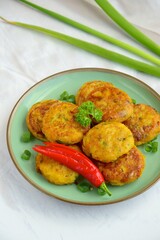 Perkedel, Indonesian fried potato minced beef patties garnish with parsley and chili in a bowl 