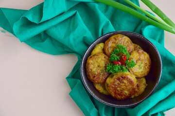 Perkedel, Indonesian fried potato minced beef patties garnish with parsley and chili in a bowl 