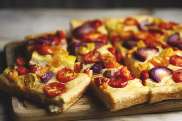 Selective focus. Homemade focaccia with cherry tomatoes and blue onions.