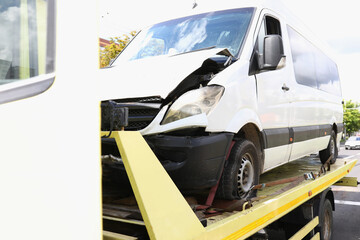 Broken hood of car that stands on tow truck. Services of insurance companies concept