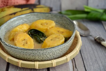 Indonesian Cuisine - Kolak Pisang or Plantain Banana Compote. Cooked with coconut milk, palm sugar and pandanus leaves. Ramadhan menu.