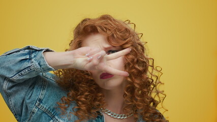 Woman dancing on yellow background. Girl making funny moves during dance