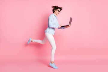 Full length body size profile side view of her she nice attractive skinny focused cheerful brown-haired girl jumping study learn use laptop isolated pink pastel color background