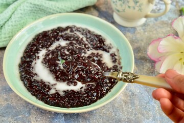Indonesian traditional dessert: Bubur Ketan Hitam or black glutinous rice porridge with coconut milk sauce. Ramadan menu