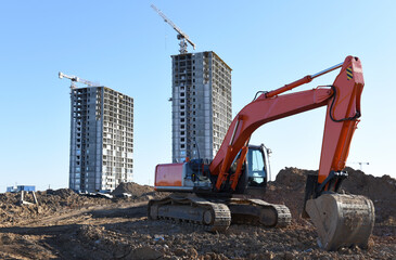 Excavator working at construction site. Backhoe on road work and earthworks. Earth-Moving Heavy...