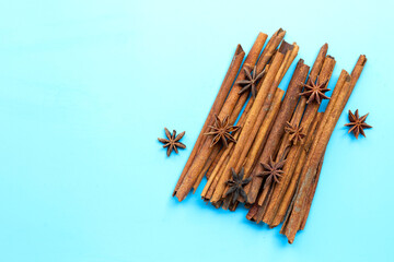 Star anis and cinnamon sticks on blue background.