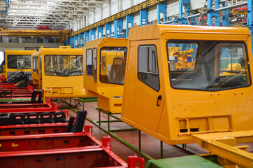 Production process of heavy mining trucks at the factory. Minin truck on the Industrial conveyor in the workshop of an automobile plant. Manufacturer of haulage and earthmoving equipment, haul trucksм