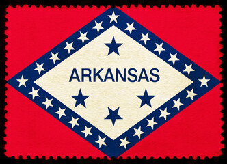 Arkansas US state flag on the old grunge postage stamp isolated on black background. Texture of old paper	