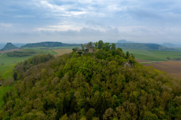 Aerial view of a forested hill with a castle ruin on top of it