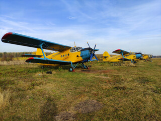 Parking yellow old piston aircraft biplanes with a propeller in the summer on the tarmac in Sunny...